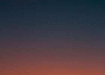 Fiery sunset with crescent moon Crescent moon and fiery orange sunset horizon